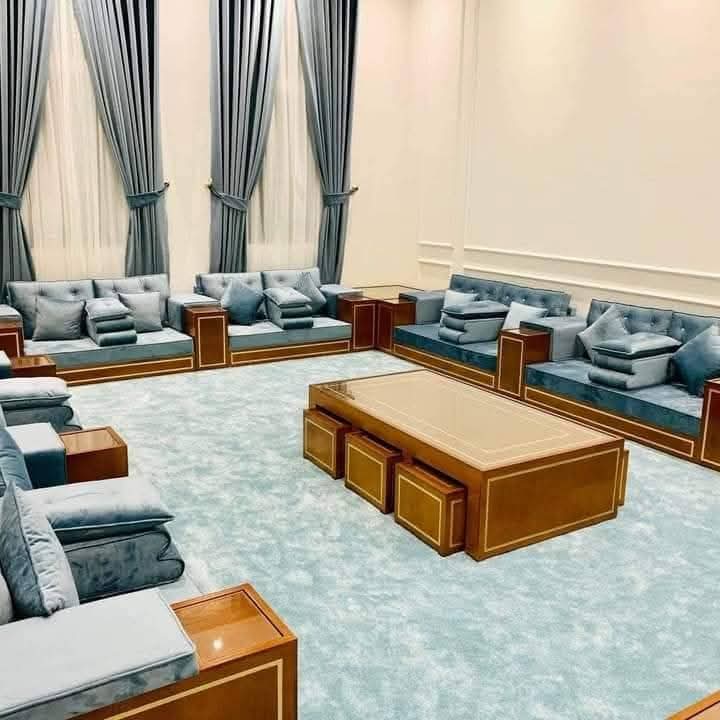Blue-grey velvet majlis seating with wood-and-brass inlay tables