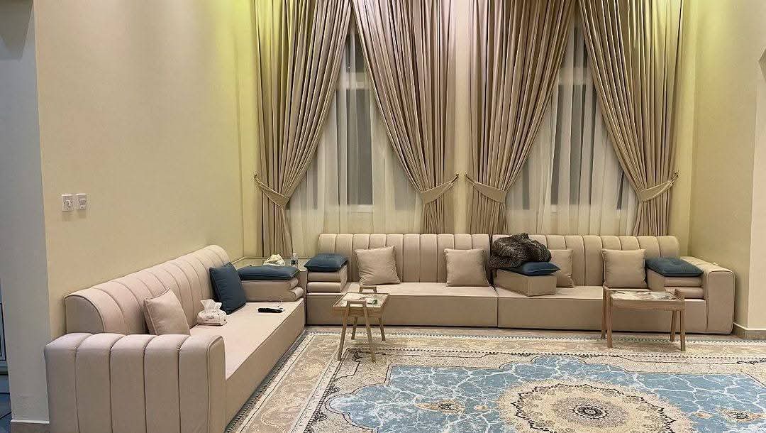 Beige channel-tufted sofa with a patterned area rug