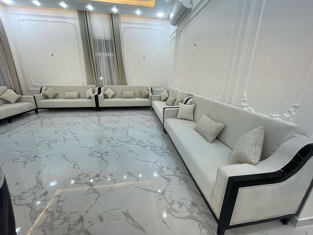 Polished marble flooring with a black-trimmed sofa
